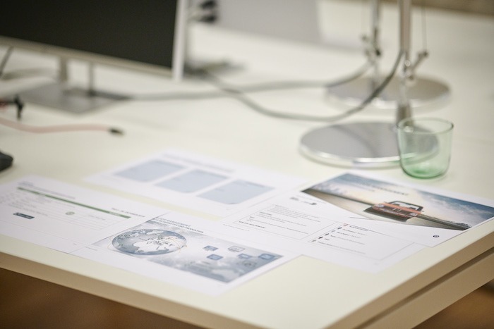 Schreibtisch mit Unterlagen und leerem Wasserglas